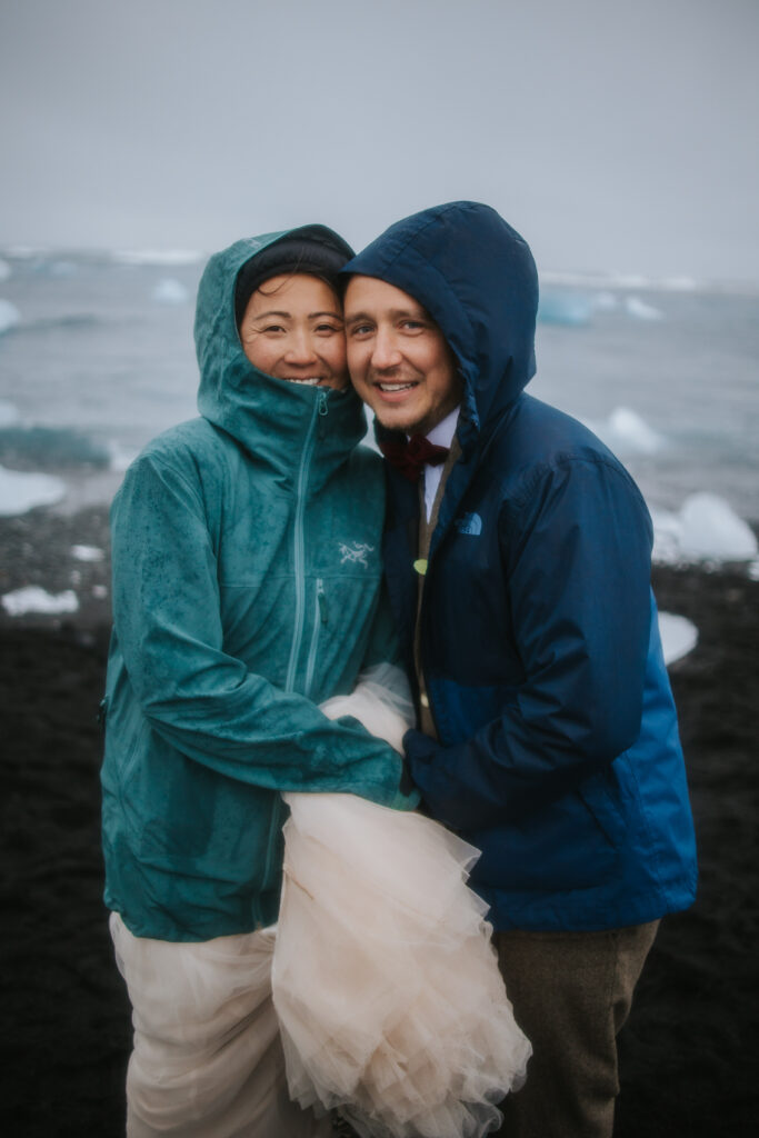 Couple smiling at their elopement photographer on their wedding day for their Iceland elopement.