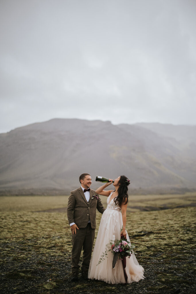 Couple drinking their champagne as they elope in Iceland.