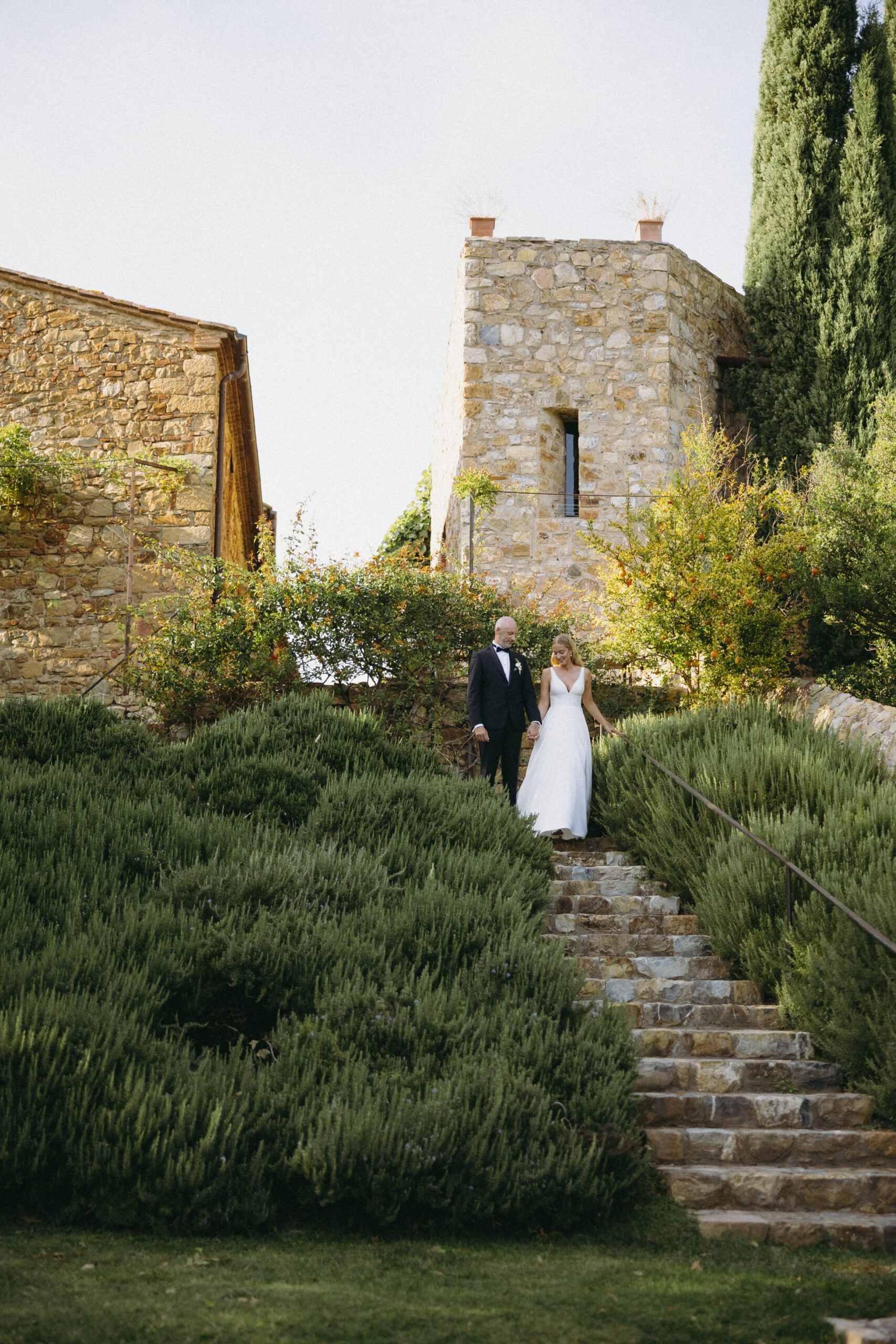 Couple walking down a stair path at Castello di Vicarello for their elopement day.