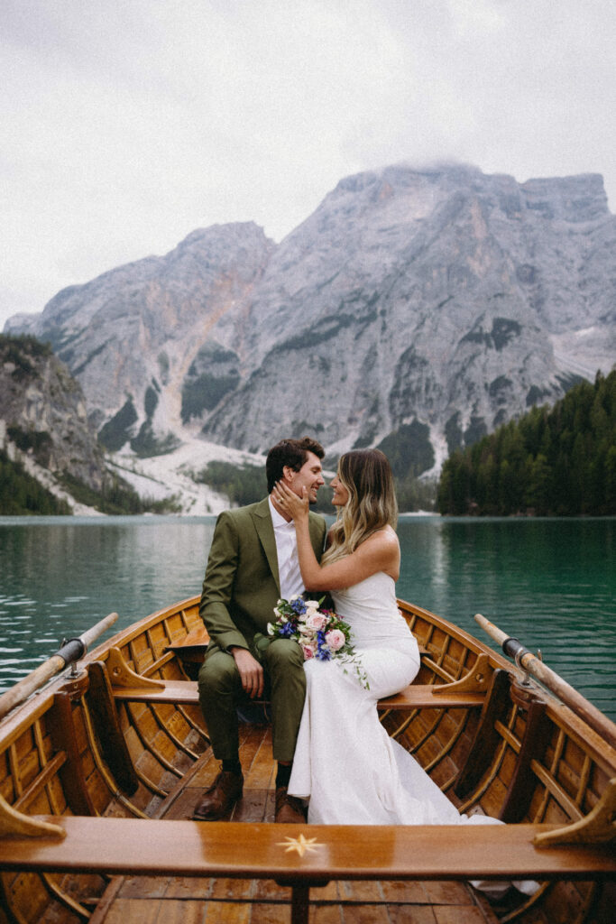 Couple sitting in a rowboat for their Italian wedding at Lago Di Braies.