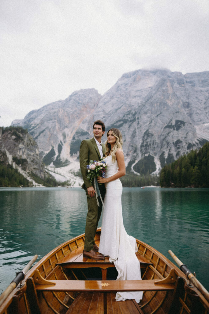 Couple posing on a boat for their Italian wedding at Lago Di Braies.